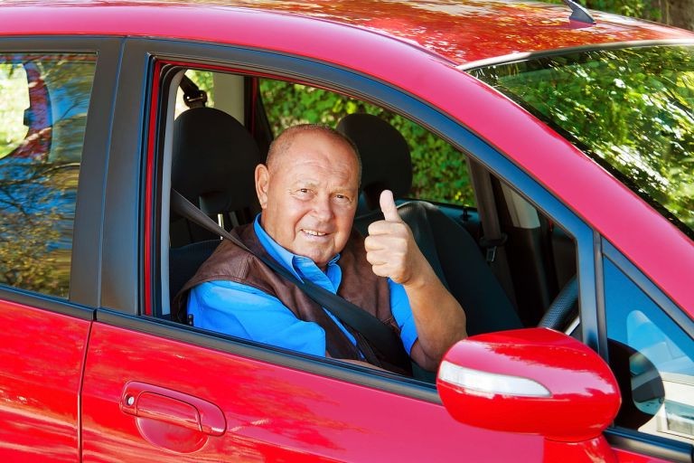 Довольный автолюбитель в отполированном авто